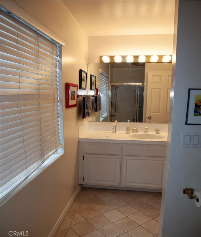 bathroom with tile patterned flooring, vanity, and a shower with shower door