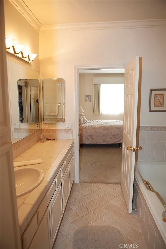 bathroom featuring tile patterned flooring, vanity, crown molding, and tiled tub