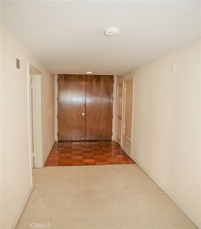 hall with baseboards and carpet floors