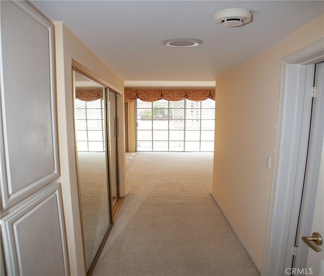 hall featuring light colored carpet