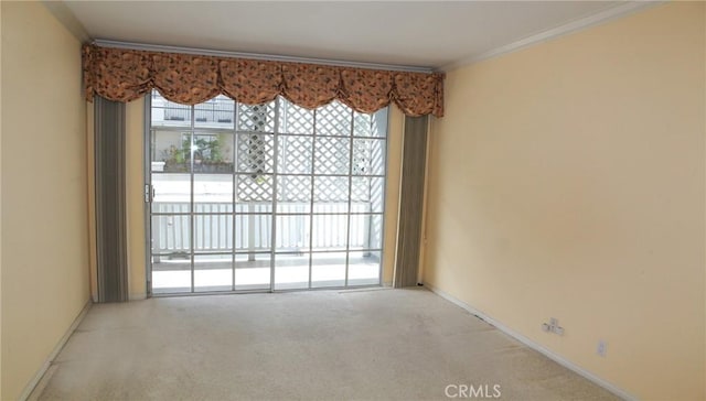 carpeted spare room featuring ornamental molding and baseboards