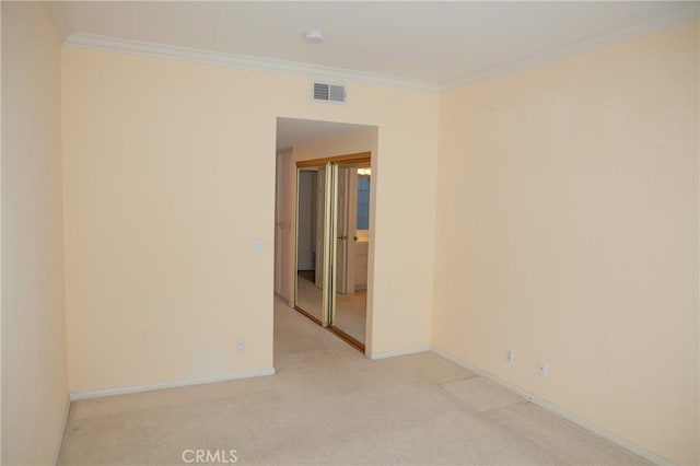 unfurnished room with baseboards, light carpet, crown molding, and visible vents