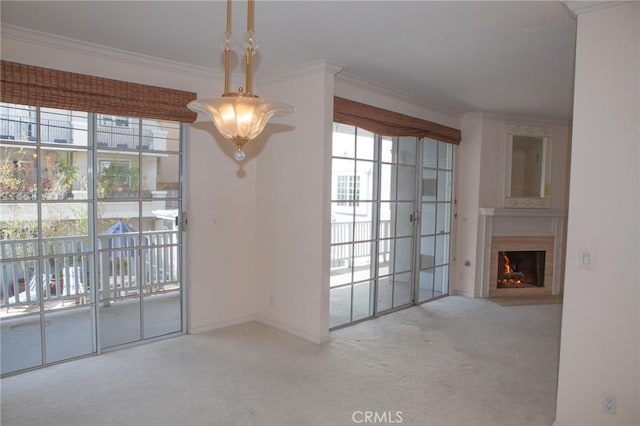 unfurnished living room featuring plenty of natural light, ornamental molding, and carpet