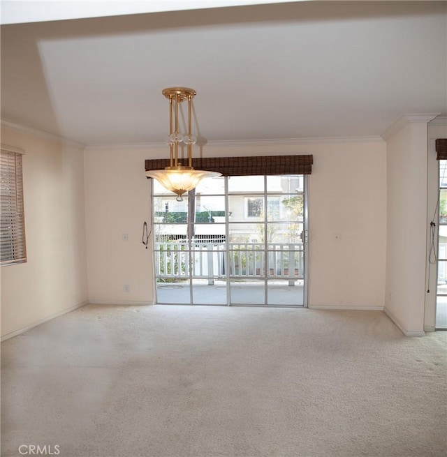 carpeted spare room with crown molding and baseboards