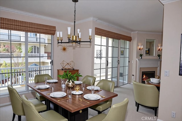 dining space with ornamental molding, a wealth of natural light, and a notable chandelier