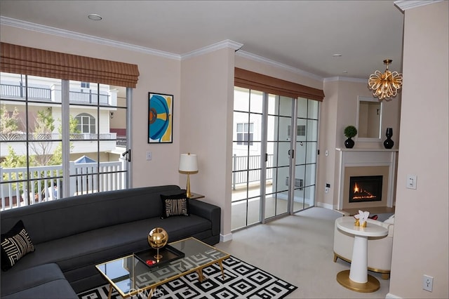 living area with crown molding, baseboards, a healthy amount of sunlight, and a notable chandelier