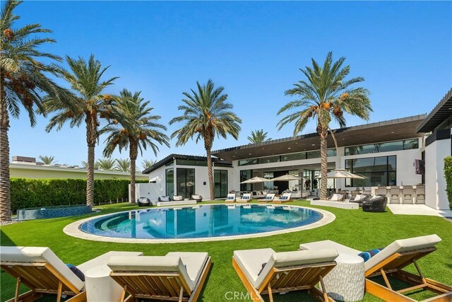 view of pool featuring a bar and a lawn