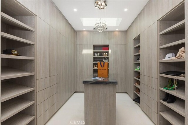 walk in closet with an inviting chandelier