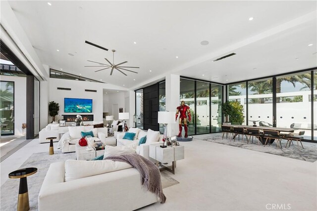 living room with expansive windows and ceiling fan