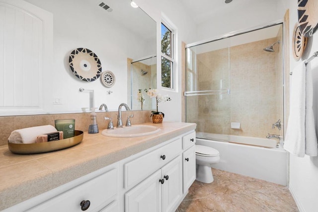 full bathroom featuring bath / shower combo with glass door, vanity, and toilet