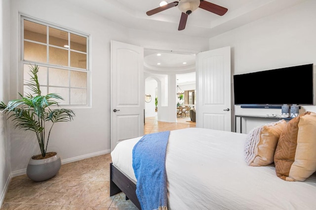 bedroom with ceiling fan and a tray ceiling