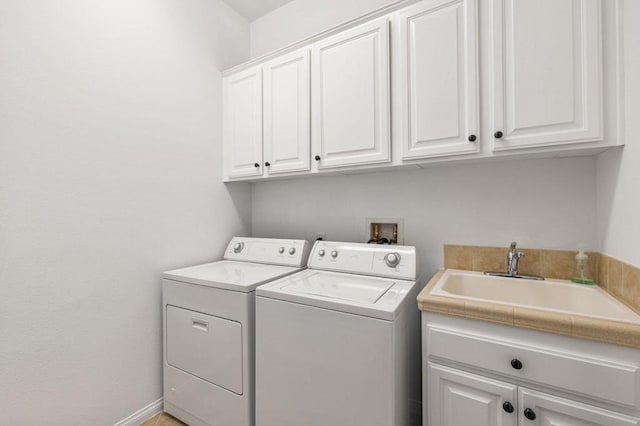 laundry room with cabinets, washing machine and clothes dryer, and sink