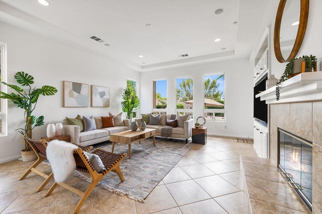 living room with a high end fireplace and light tile patterned floors