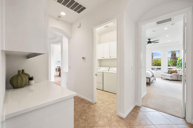 hall featuring light tile patterned floors and washer and dryer