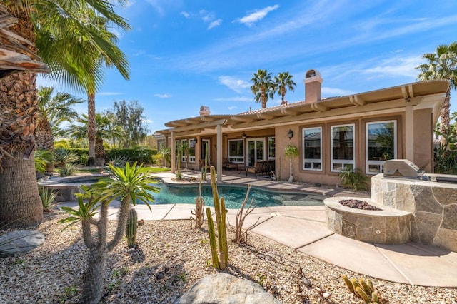 view of swimming pool featuring a patio, an outdoor kitchen, an outdoor fire pit, grilling area, and a pergola