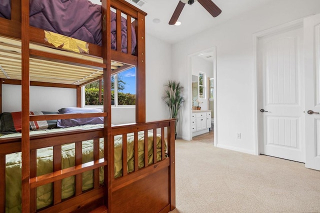 carpeted bedroom with connected bathroom and ceiling fan