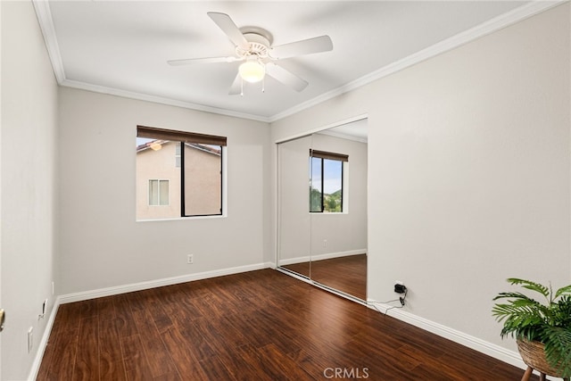 unfurnished bedroom with a closet, dark hardwood / wood-style floors, ceiling fan, and ornamental molding