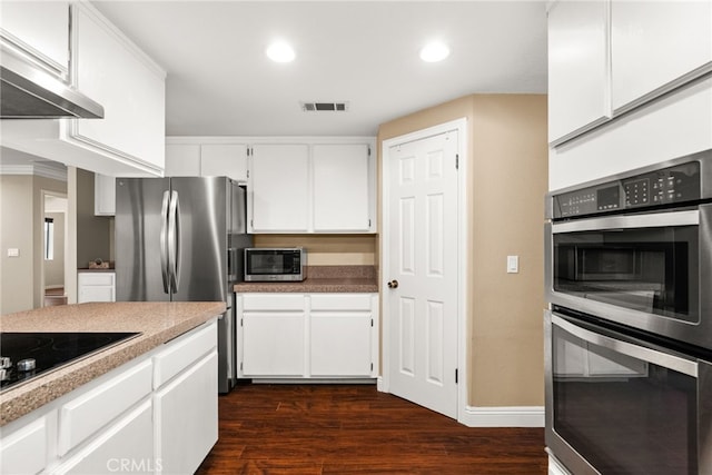 kitchen featuring dark hardwood / wood-style flooring, white cabinetry, stainless steel appliances, and extractor fan