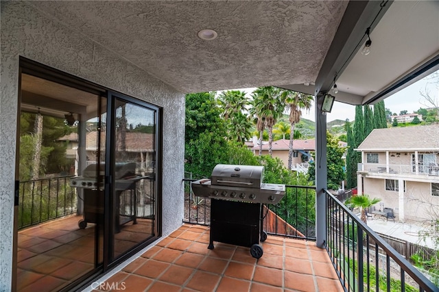 view of patio with area for grilling and a balcony