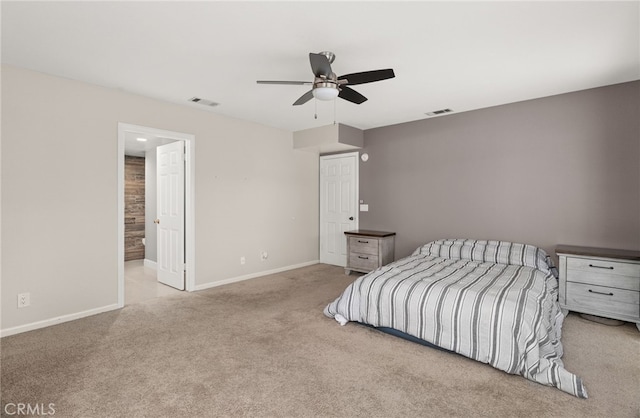 unfurnished bedroom with ceiling fan, light colored carpet, and connected bathroom