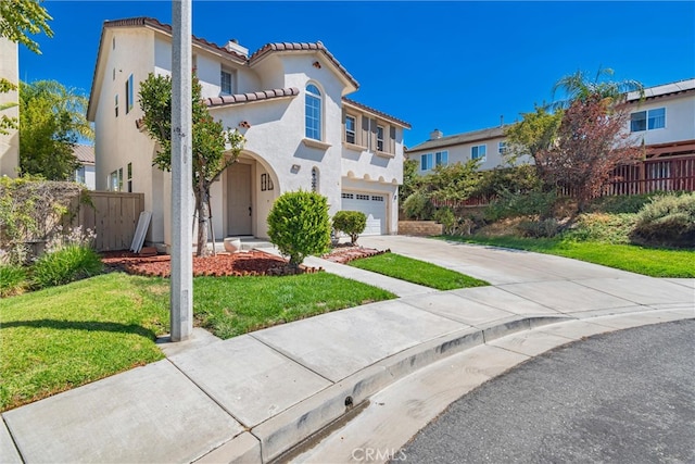 mediterranean / spanish-style house with a garage and a front lawn