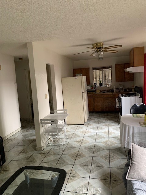 kitchen with ceiling fan, a textured ceiling, and white appliances