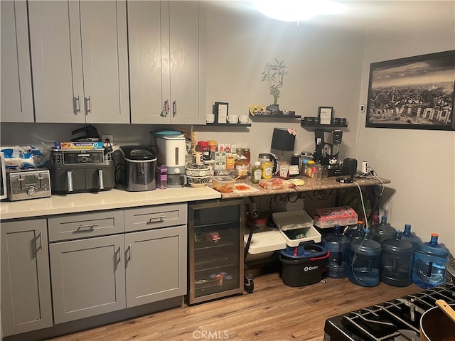 kitchen featuring gray cabinetry, beverage cooler, and light hardwood / wood-style floors