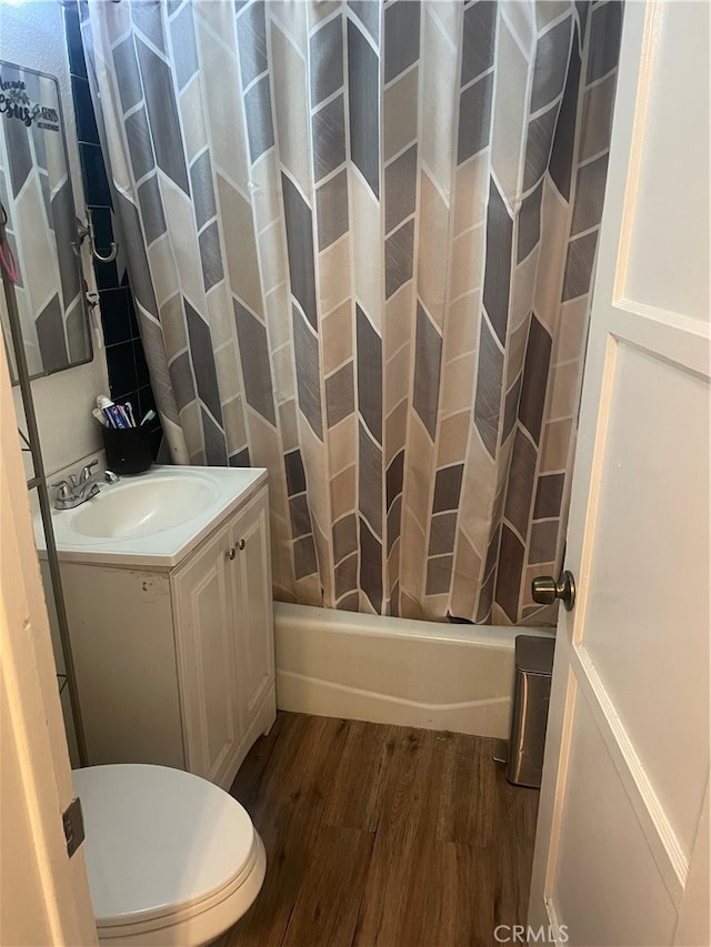 full bathroom with vanity, toilet, shower / bath combo with shower curtain, and hardwood / wood-style flooring