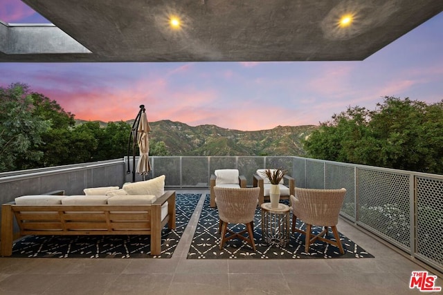 patio terrace at dusk with outdoor lounge area and a mountain view