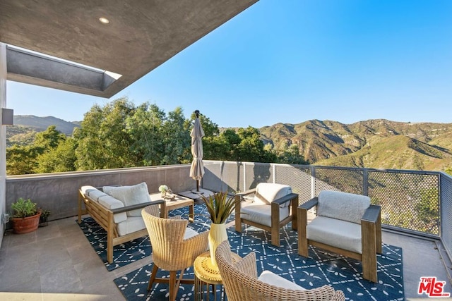 exterior space with a patio, an outdoor living space, and a mountain view