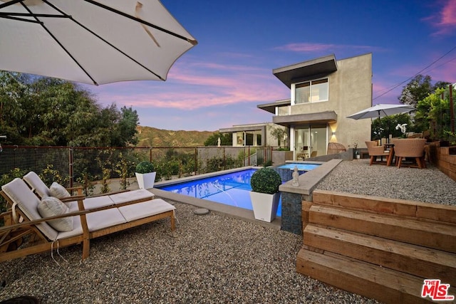 pool at dusk with a patio