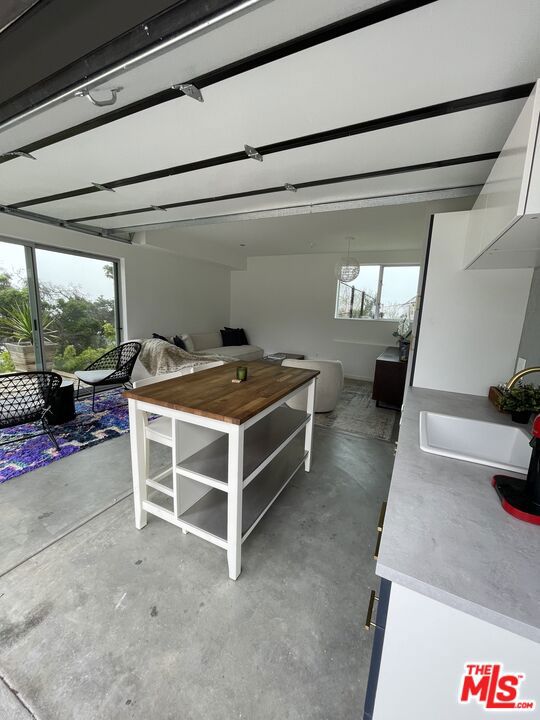 interior space with sink, concrete flooring, and white cabinets