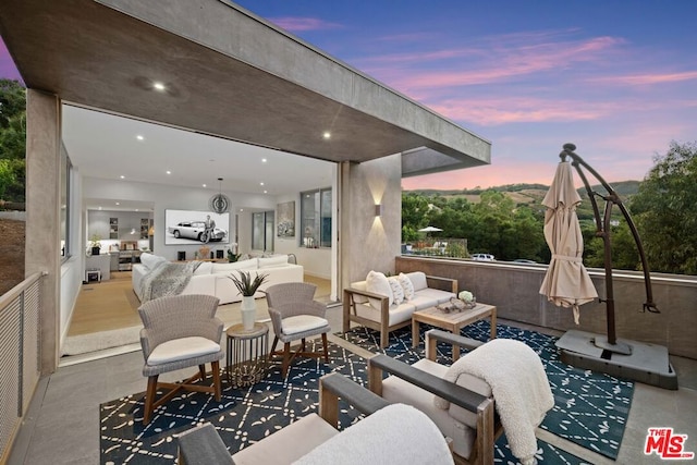 patio terrace at dusk featuring an outdoor hangout area