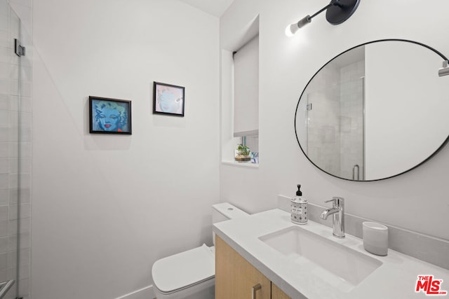 bathroom featuring vanity, toilet, and an enclosed shower