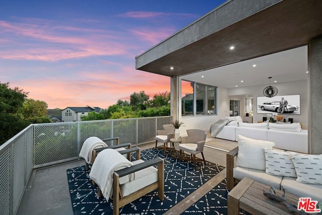 patio terrace at dusk with a balcony and an outdoor hangout area