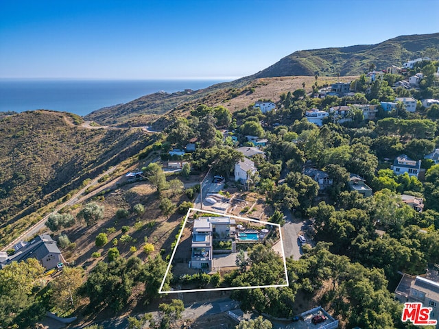 drone / aerial view featuring a water and mountain view