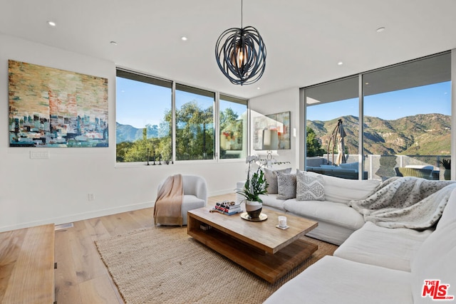 living room with a mountain view, light hardwood / wood-style flooring, and floor to ceiling windows