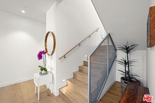 stairs featuring hardwood / wood-style flooring