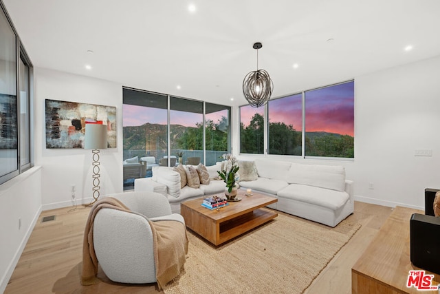 living room featuring a notable chandelier and light hardwood / wood-style flooring