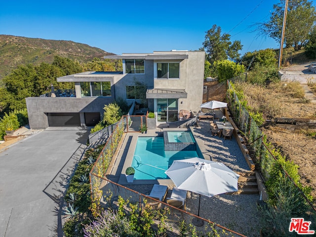 back of house featuring a mountain view, a fenced in pool, and a patio area