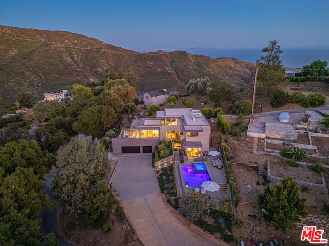 aerial view at dusk featuring a mountain view