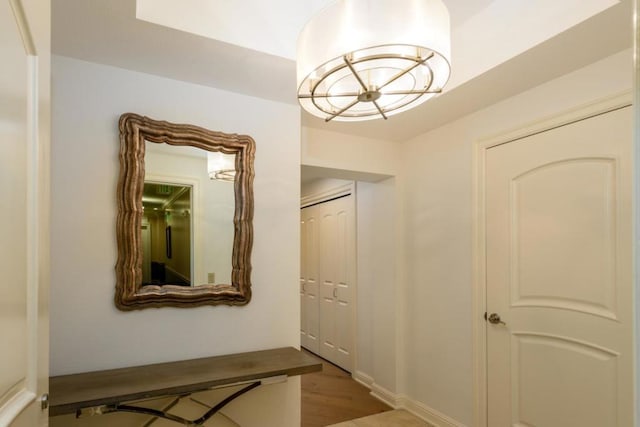 hallway featuring a chandelier and light hardwood / wood-style floors