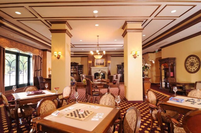 dining space featuring decorative columns, french doors, ornamental molding, and a notable chandelier