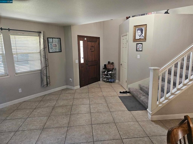 tiled entryway featuring a textured ceiling