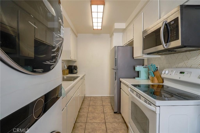 kitchen featuring light tile patterned floors, white cabinetry, and white range with electric cooktop