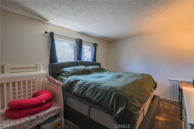 bedroom with dark carpet and a textured ceiling