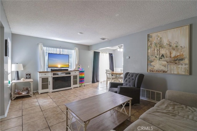 living room with light tile patterned floors, a textured ceiling, and ceiling fan