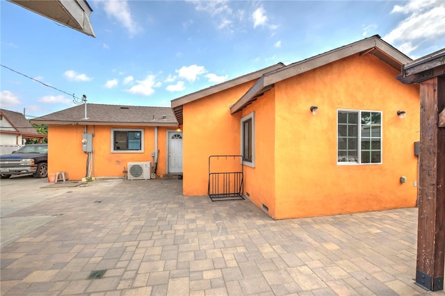 rear view of property with ac unit and a patio area