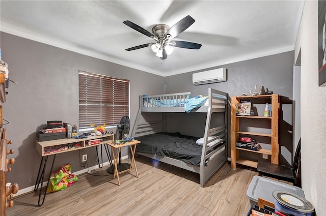 bedroom featuring ceiling fan, light wood-type flooring, and a wall unit AC