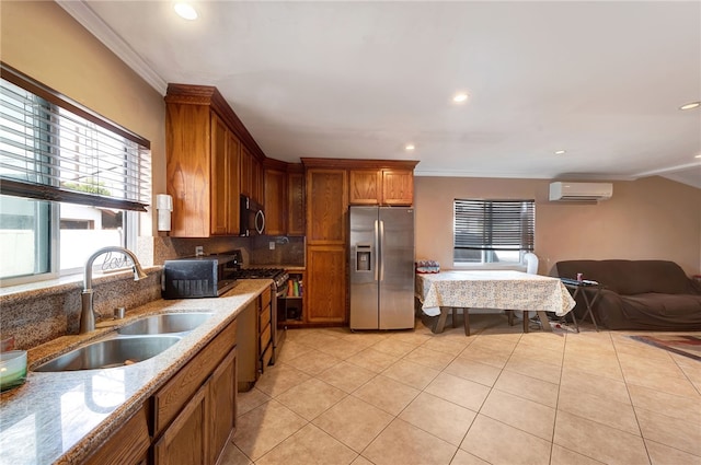 kitchen featuring sink, decorative backsplash, stainless steel appliances, light stone countertops, and a wall unit AC